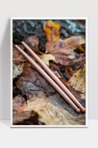 秋日落叶中静静躺着的木质鼓棒特写